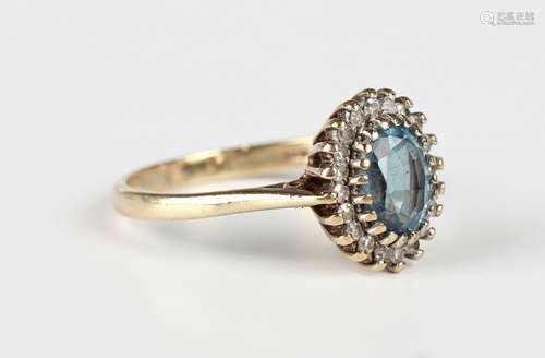 A 9ct gold, blue topaz and diamond oval cluster ring, claw s...