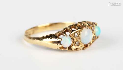 An 18ct gold, opal and diamond ring, mounted with three opal...