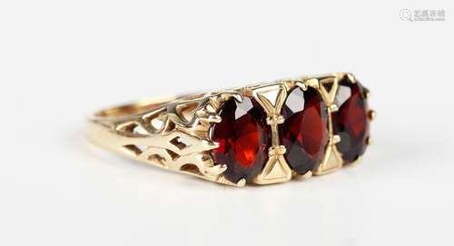 A 9ct gold and garnet three stone ring, claw set with a row ...