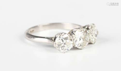 A platinum and diamond three stone ring, claw set with a row...