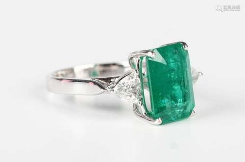 A white gold, emerald and diamond three stone ring, claw set...