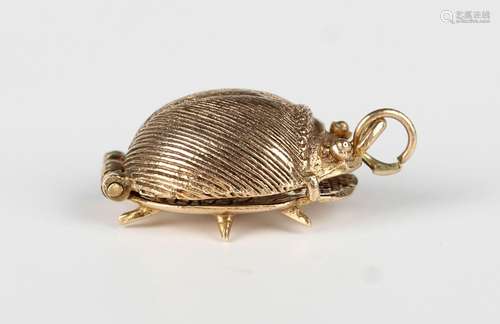 A 9ct gold pendant charm, designed as a beetle opening to re...