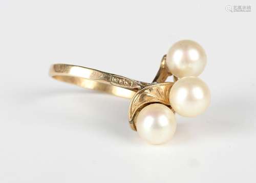 A gold ring, mounted with three cultured pearls in a twist d...