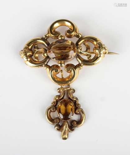 A gold and citrine brooch in a shaped oval scroll pierced de...