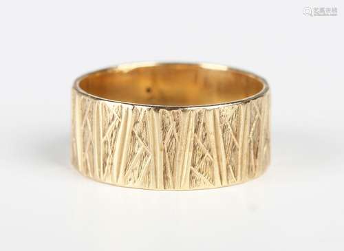 A 9ct gold wide band wedding ring with textured decoration, ...