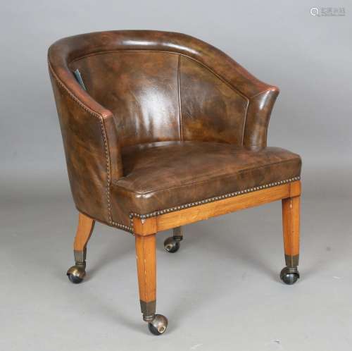 A 20th century tub back easy chair, upholstered in brown lea...