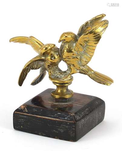 Bronze car mascot in the form of two birds raised on a woode...