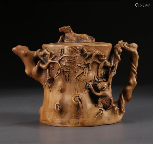 A STUMP-SHAPED PURPLE CLAY TEAPOT.