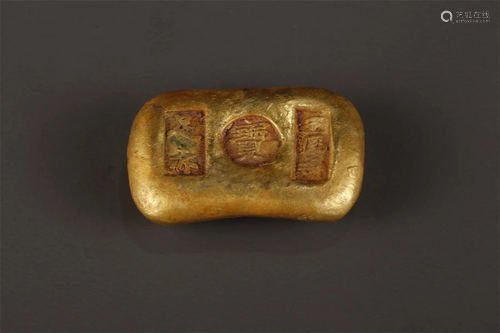 A GILT BRONZE INGOT-SHAPED SCULPTURE.