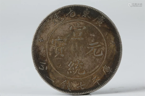 A SILVER COIN WITH LETTERING "XUANTONGYUANBAO".