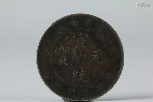 A SILVER COIN WITH LETTERING "XUANTONGYUANBAO".