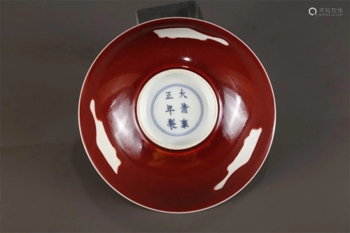 A RUBY GLAZED BOWL WITH WHITE FISH DESIGN.