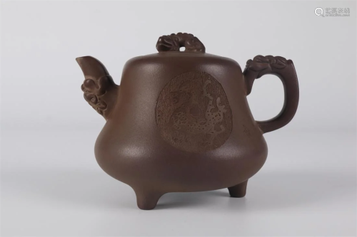 A PURPLE CLAY TEAPOT WITH DRAGON DESIGN.