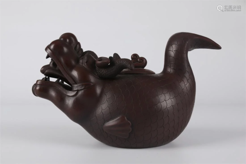 A PURPLE CLAY TEAPOT WITH CRUCIAN-SHAPED BODY.