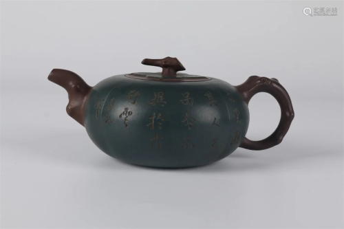 A PURPLE CLAY TEAPOT WITH CARVED POEM DESIGN.