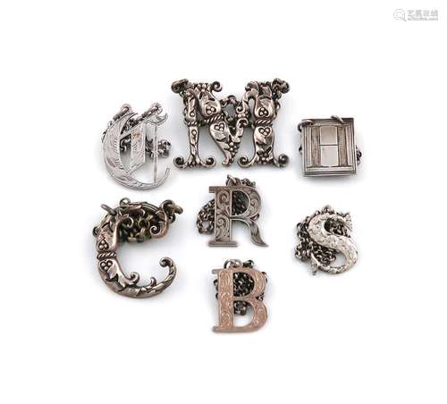 A collection of antique silver Cut-out letter wine labels, v...