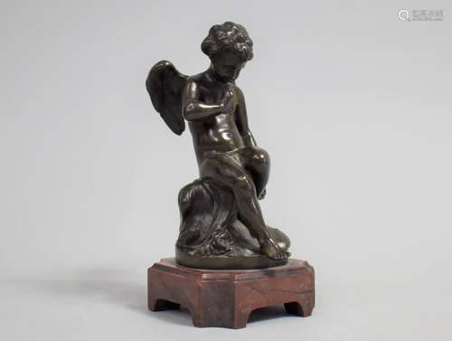 A Bronze Study of Seated Pensive Cherub Set on Red Marble Pl...