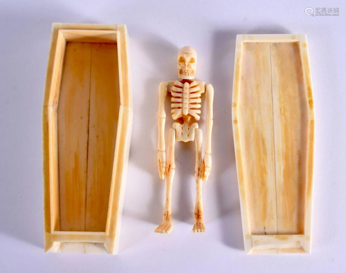 A CONTEMPORARY CARVED BONE SKELETON IN A CASKET. 12 cm x 4.5...