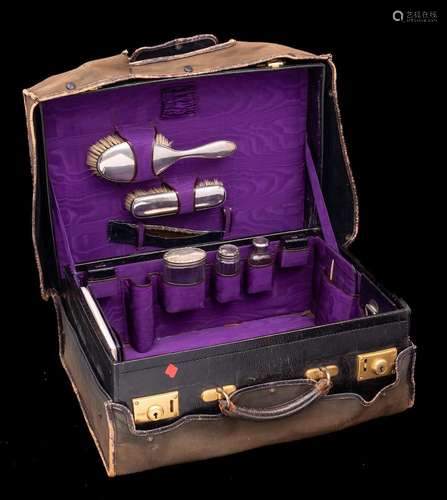 A leather travelling vanity case: fitted with silver mounted...