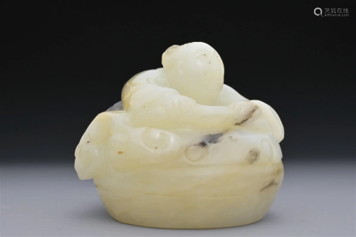 A CHINESE GREENISH-WHITE AND BLACK JADE CARVING OF BOY ON DR...