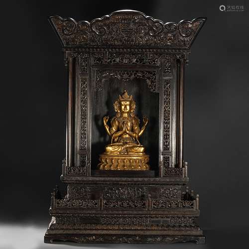 A gilt bronze statue of a seated Buddha in a red sandalwood ...