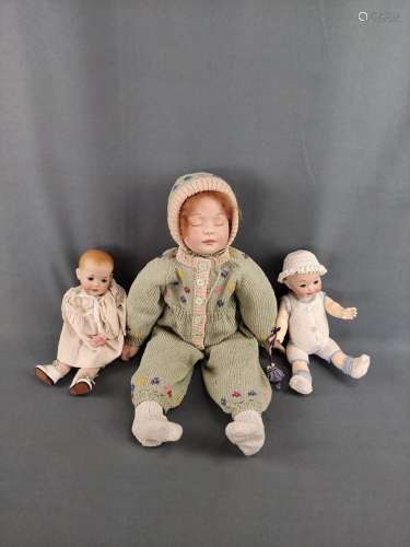 Three porcelain dolls, small doll in white nightgown with fl...