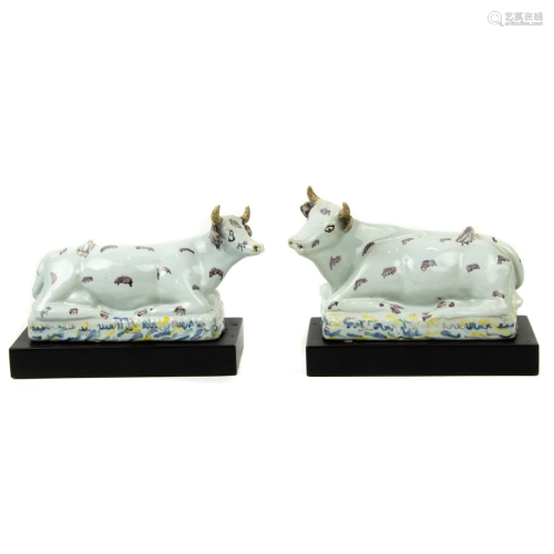 A pair of French faience models of recumbent cows