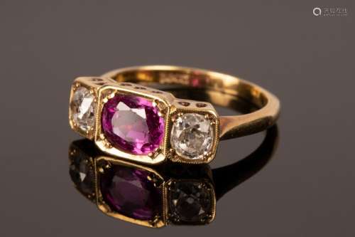 A ruby and diamond three-stone ring in an unmarked yellow me...