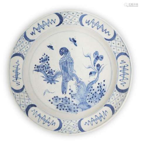 A Delft charger, 18th century, painted with a parrot perched...