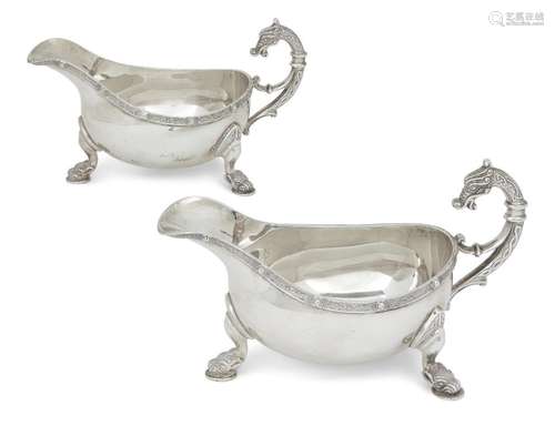 A pair of silver gravy boats with zoomorphic handles