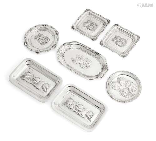 A group of seven putti-decorated silver pin dishes comprisin...