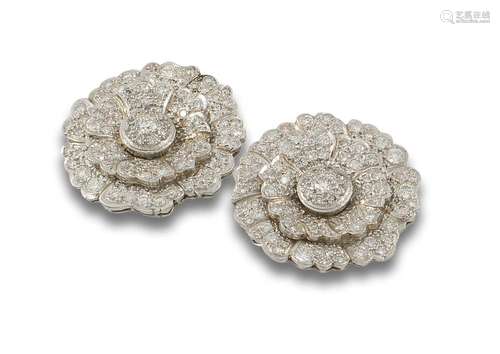 Large platinum flower-shaped earrings studded with brilliant...