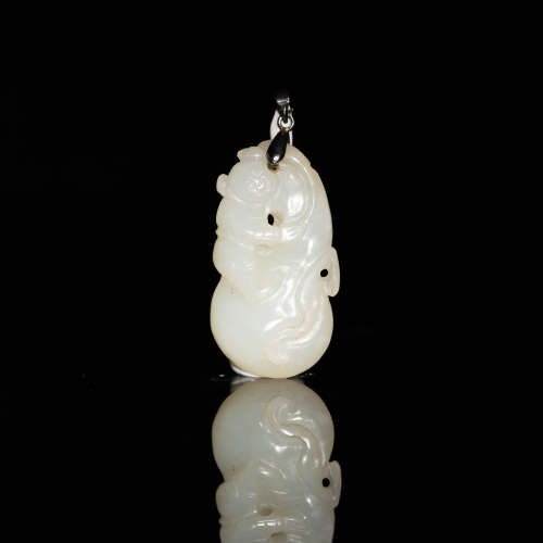 A Chinese carved white jade toggle in the form of a boy  19t...