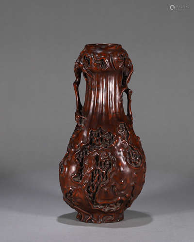 A carved boxwood vase with garlic shaped mouth