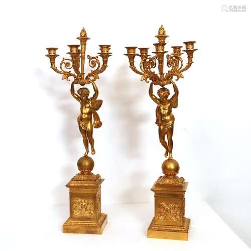 PAIRE DE CANDÉLABRES en bronze doré présentant des putti aux...