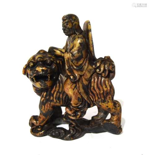 A Chinese Stone Carving of an Immortal Riding a Lion Dog