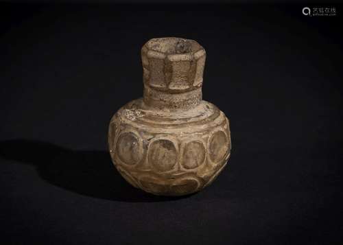 A LATE SASANIAN CUT GLASS BOTTLE CIRCA 6TH CENTURY A.D