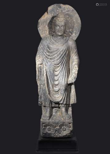 A MONUMENTAL GHANDARA STANDING BUDDHA SCHIST FIGURE WITH HAL...