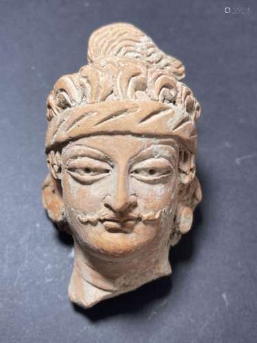 A TERRACOTTA HEAD FRAGMENT, POSSIBLY GANDHARA OR LATER