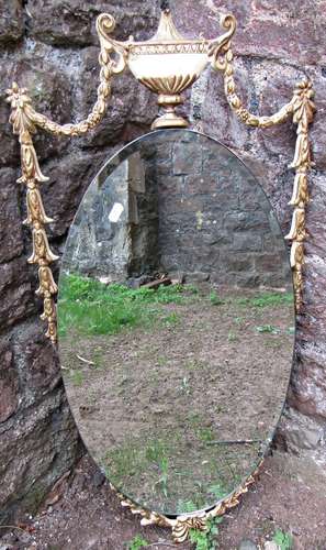 A oval mirror with bevelled edge plate and gilt highlighted ...