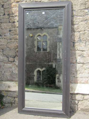 A dressing mirror in a moulded ebonised frame 176 x 82 cm