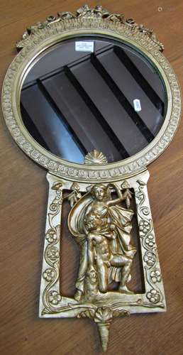 A small circular gilt framed wall mirror with decorative cla...