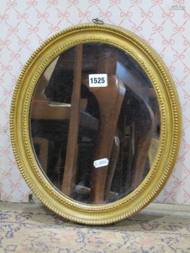 A simple Georgian oval gilt framed mirror with beaded border...