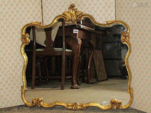 A decorative gilt framed wall mirror with repeating shaped a...