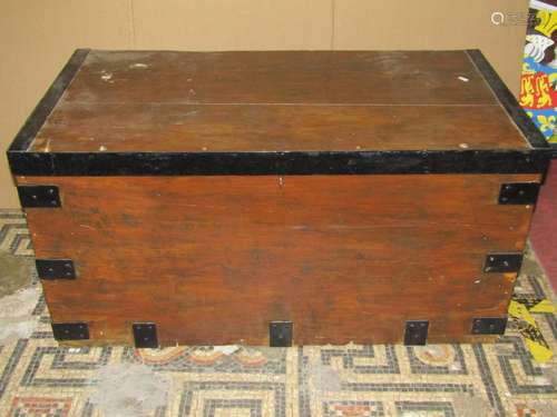 An old stained pine chest with hinged lid and steel banded f...