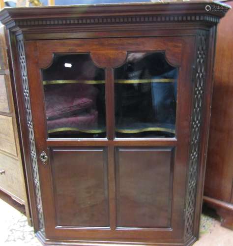 A Georgian style mahogany hanging corner cupboard, the door ...