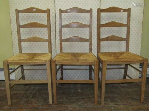 A Harlequin set of three pale oak ladderback chairs, almost ...