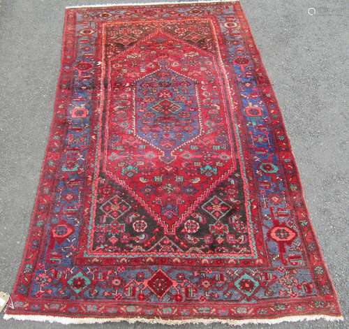 An old Middle Eastern rug with a central medallion and styli...