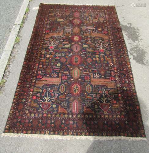 A Middle Eastern rug decorated with stylised birds and flowe...