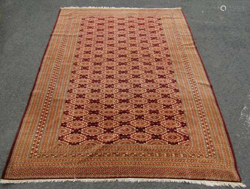 A large Turkoman carpet with a field of brown interspersed w...